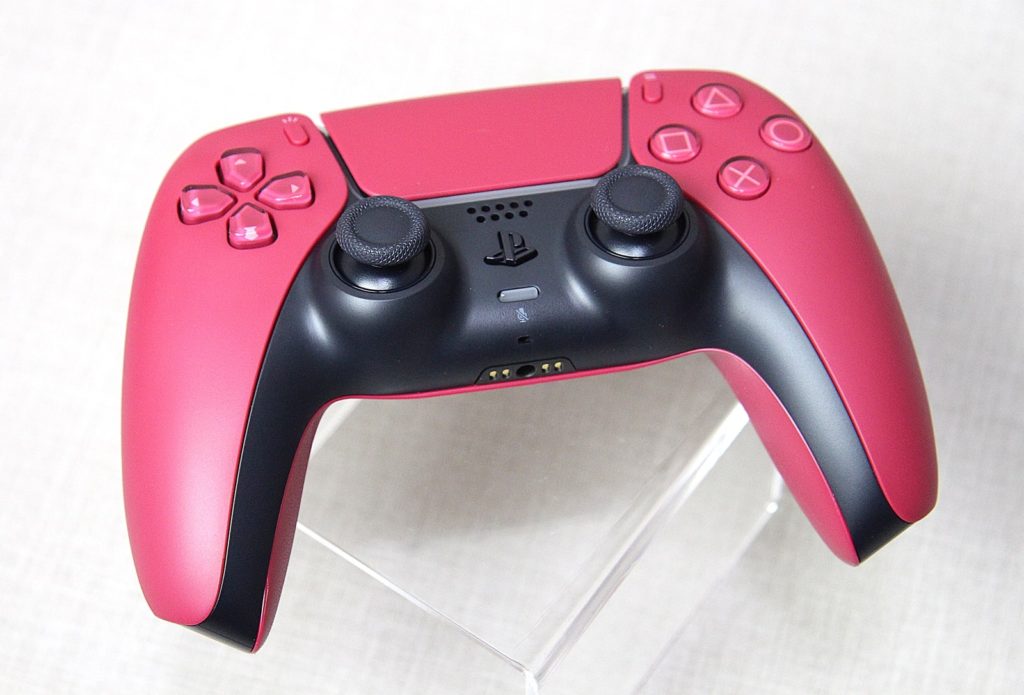 DualSense Cosmic Red położony na plecach