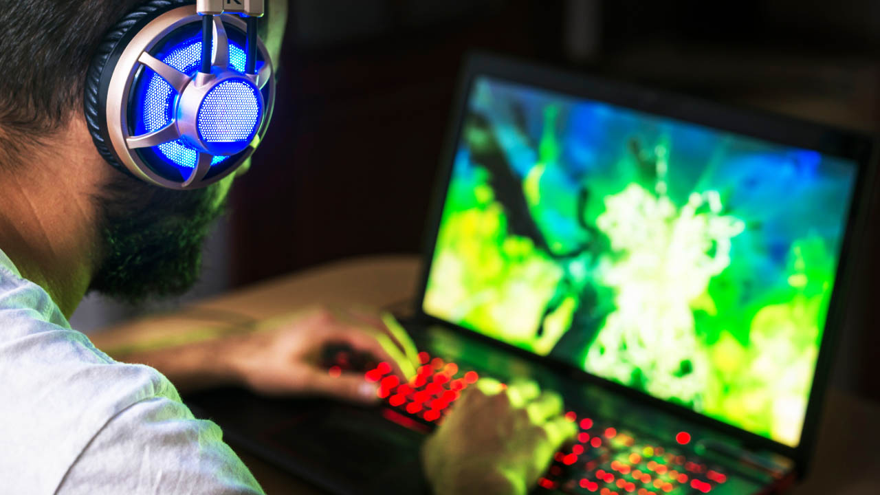 Tani laptop dla gracza - mężczyzna korzystający z gamingowego laptopa