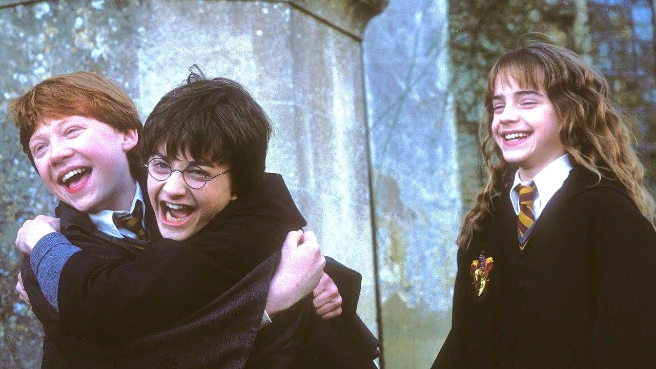 Harry ściska Rona, Hermiona się uśmiecha na screenie z filmu Harry Potter i Kamień Filozoficzny