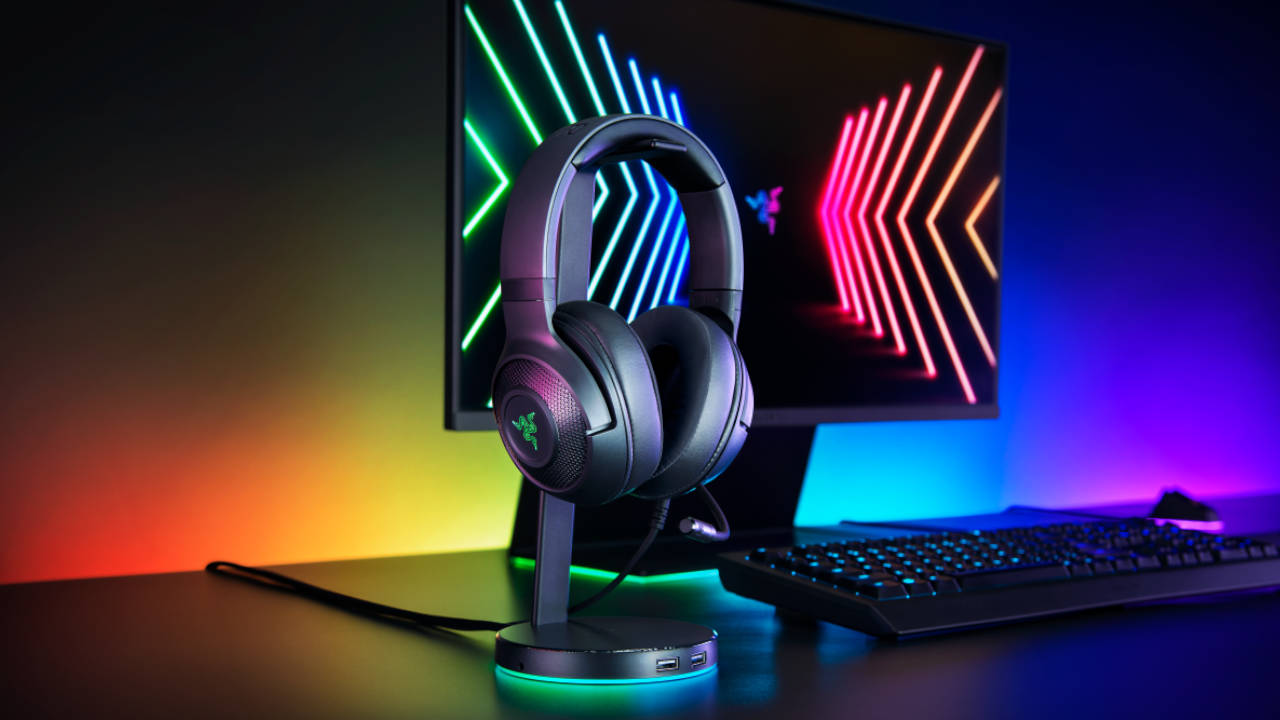 Razer - słuchawki gamingowe na stojaku, w tle monitor gamingowy i podświetlenie RGB